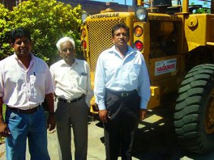 Morgan, Yogan and Athimulam Nadasen with one of the very first Cat 920 wheel loaders acquired by Nadasens Transport.